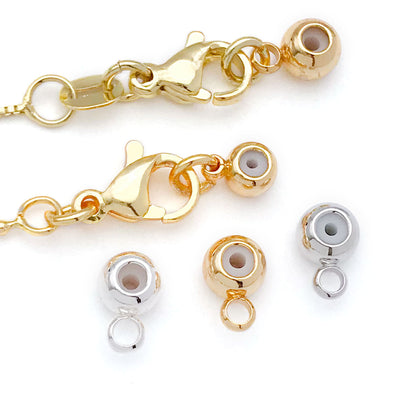 Silver-tone crimp bead jewelry findings arranged on a light background