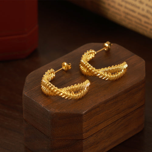 Gold twisted rope open C studs on dark wood block