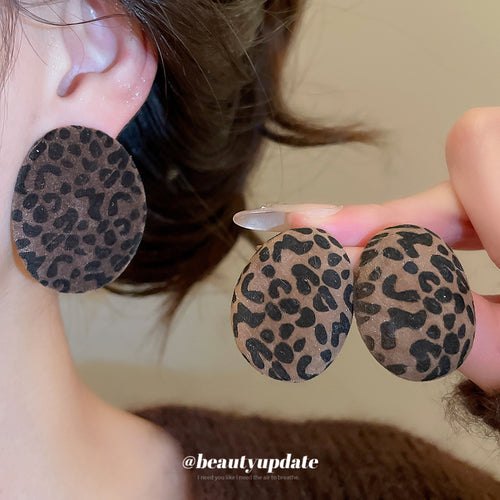 Close view of the colors and surface details on brown leopard oval flocked stud earrings