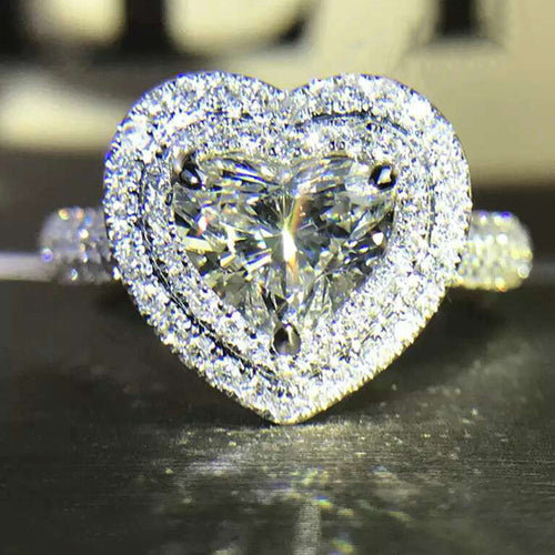 Front view showing a heart-shaped center with a clear halo and stone-set band