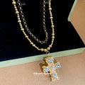 Gold Tone Layered Necklace With Blue Stone Cross Pendant view 2
