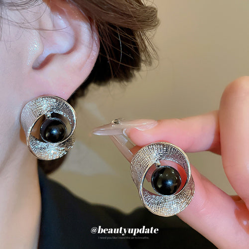 Domed silver-tone textured rings surrounding glossy black centers shown in a front product view