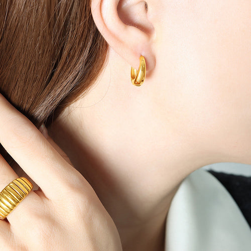 Gold geometric huggie hoop earring worn close to ear