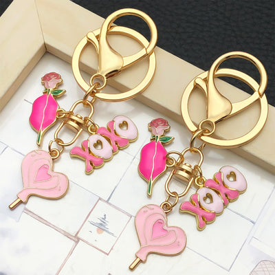 Overview showing the available color and design variations of the pink and red rose heart metal keychain
