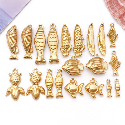 Gold-tone mermaid and shell charms arranged on a light background