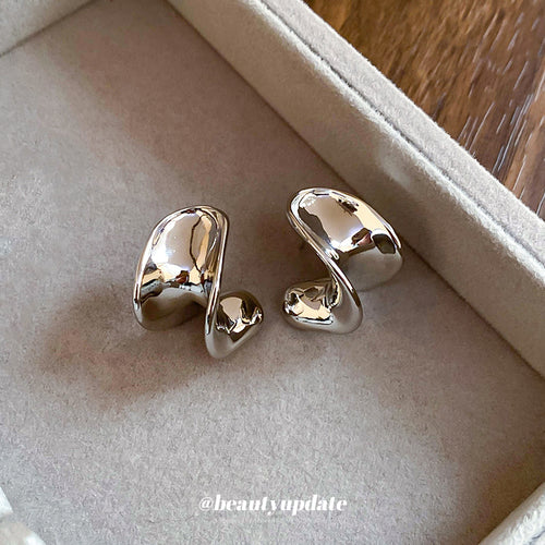 polished silver tone sculptural c hoop stud earrings displayed from a second angle