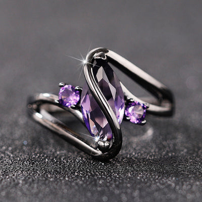 Gunmetal purple marquise CZ ring on dark glitter surface