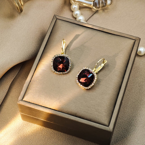 Gold burgundy cushion gem halo earrings in taupe jewelry box