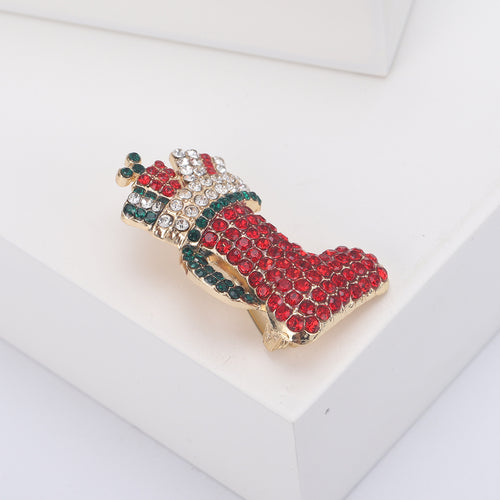 Angled red stocking pin clear green stones gift bow on white block