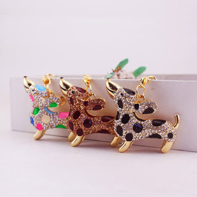 Three gold-tone spotted dog charms in clear, brown, and multicolor finishes.