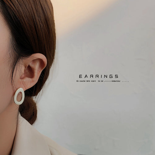 Cream hollow oval glaze stud worn on ear side profile