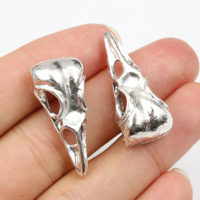 Overview of elongated bird-skull silhouettes with open eye sockets and smooth silver-tone surfaces