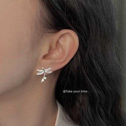 Model wearing silver flying bird earring with crystal