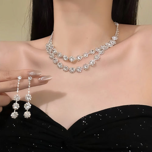 Silver double layer crystal necklace worn with drop earrings held