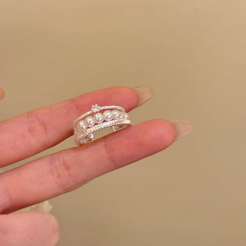 Close silver pearl stack ring with clear accent on index finger beige background