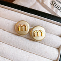 Cream Round Stud Earrings with Gold Letter M Detail view 6