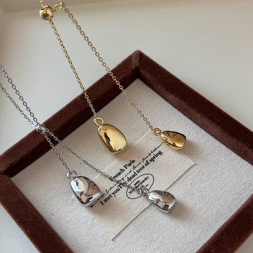 minimal teardrop pendant lariat necklace in gold tone shown in an on-ear styling view