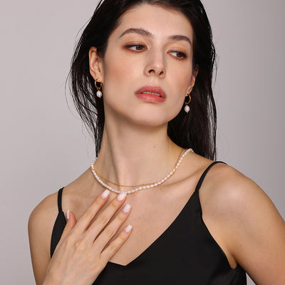 Model wearing gold double layer pearl and chain necklace