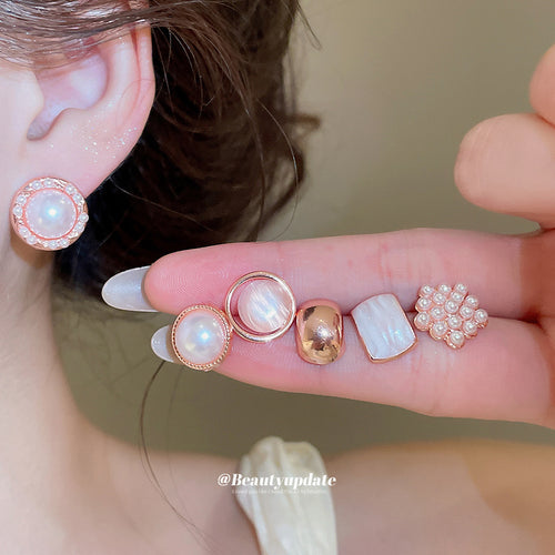 Large pearl halo stud worn with other rose gold pearl shell styles on fingers
