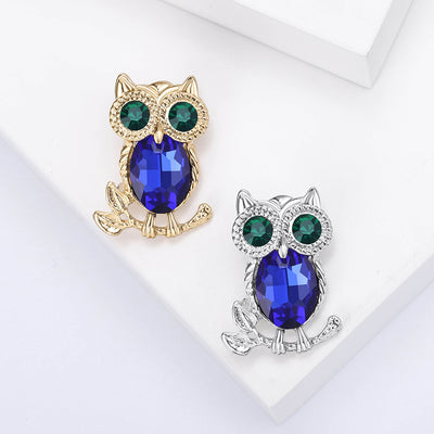 Gold and silver owl brooches with blue bodies green eyes