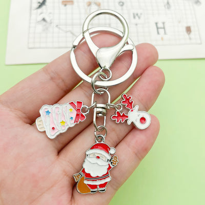 Image 1 showing a person holding a keychain with santa claus.