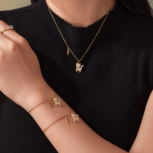 Model wearing gold cat pendant necklace with matching cat bracelets