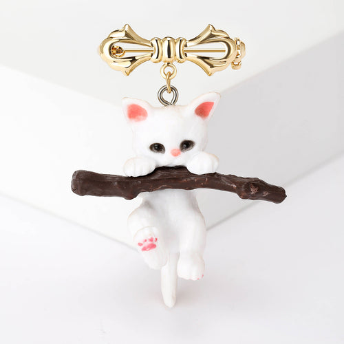 White enamel cat hanging from branch with gold bow pin