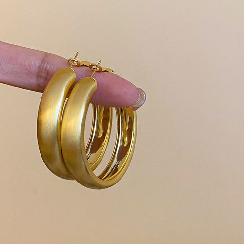 Wide Brushed Gold Tone Layered Hoop Statement Earrings shown in a display view