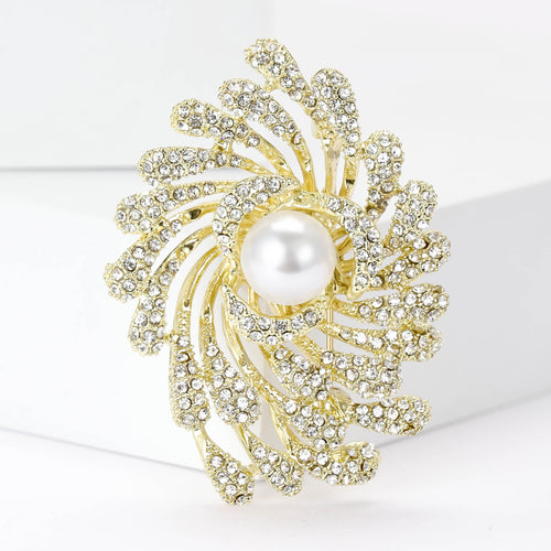 Gold pearl firework swirl brooch close-up on white display blocks