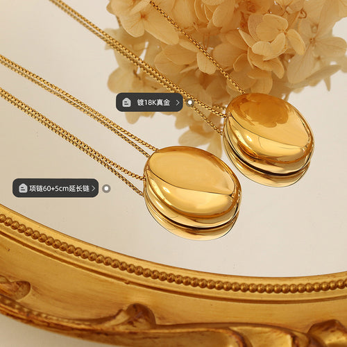 Two gold oval pendants on mirror with length and plating labels