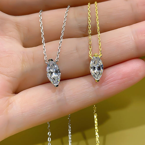 Both tone marquise pendants resting across an open palm