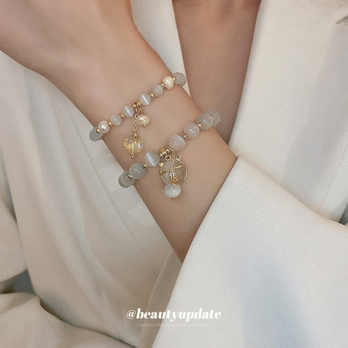 three unrelated bracelets with pale beads, heart links, and round charms shown worn in a styled second view