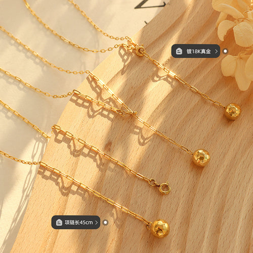 Close-up of gold paperclip chain, clasp, and hammered balls with length labels