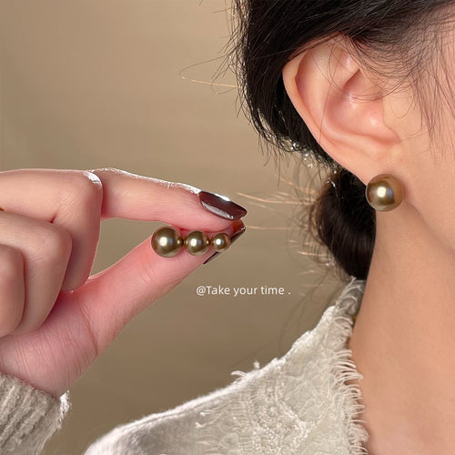 Mocha pearl size comparison on hand and worn on ear