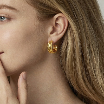 Gold triple C-shape textured hoop earring worn in profile