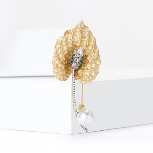 Calla lily brooch angled on white blocks with dangling pearl