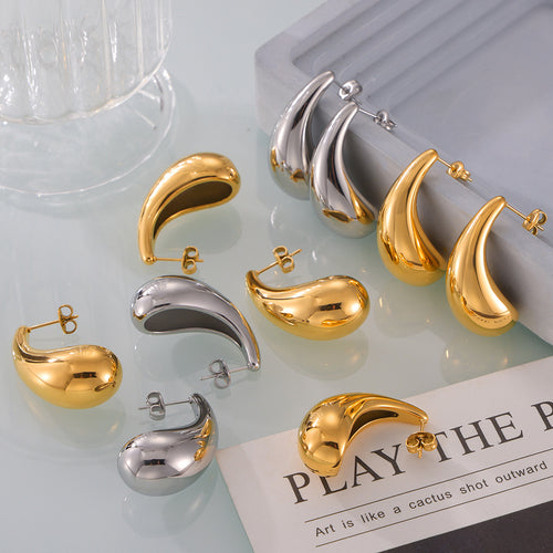 Close-up gold polished teardrop stud earring on ear