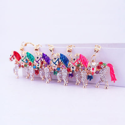 Six rhinestone horse keychains with assorted mane and tail colors arranged in a row.