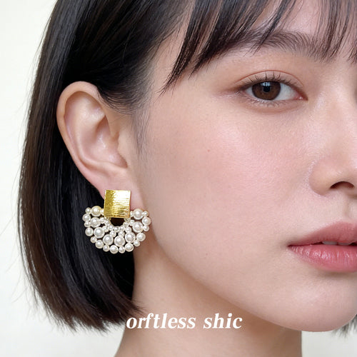 Model wearing gold square pearl fan drop stud earring