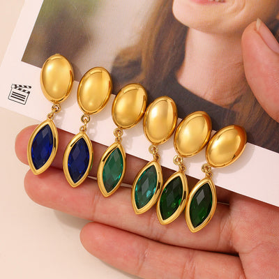 Hand holding six gold marquise glass drop earrings in blue and green