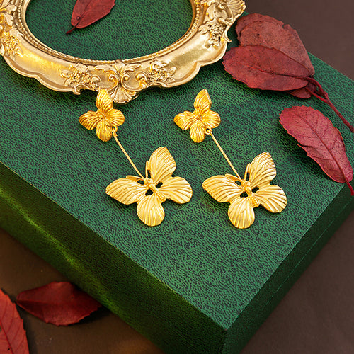 Gold double butterfly drop earrings on green box with gold frame
