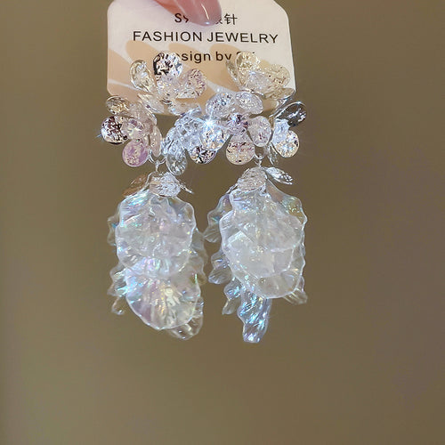 Styled view of clear petal flower earrings with crystal clusters in two tones