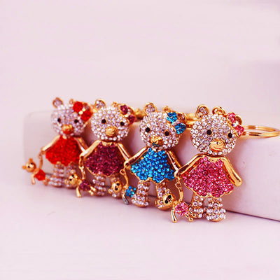 Four rhinestone bear keychains in red, purple, blue, and pink stand in a row.