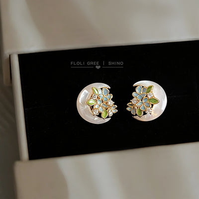 Gold mother-of-pearl crescent flower studs in black jewelry drawer