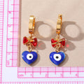 Gold Tone Bow and Heart Evil Eye Huggie Drop Earrings view 4
