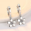 White Flower Charm Huggie Hoop Earrings in Silver Tone view 2
