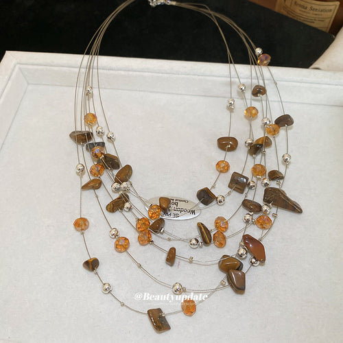 Layered brown stone silver bead necklace laid in white tray