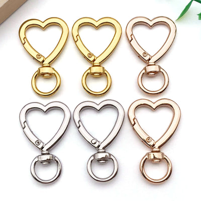 Metallic swivel clasp jewelry findings arranged on a light background