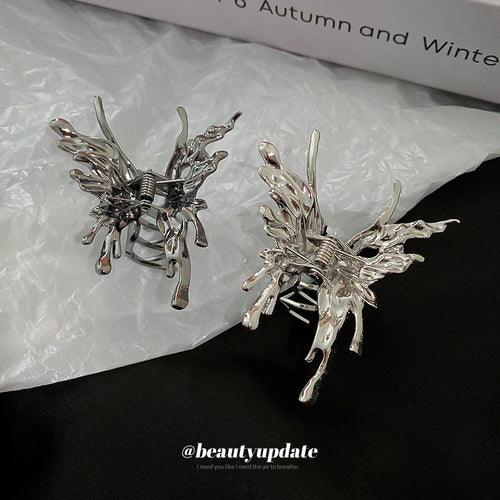 silver-tone butterfly hair claw with irregular flowing wings shown in the first close product view
