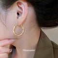 Gold Tone Twisted Medium Hoop Earrings with Detailed Finish view 3